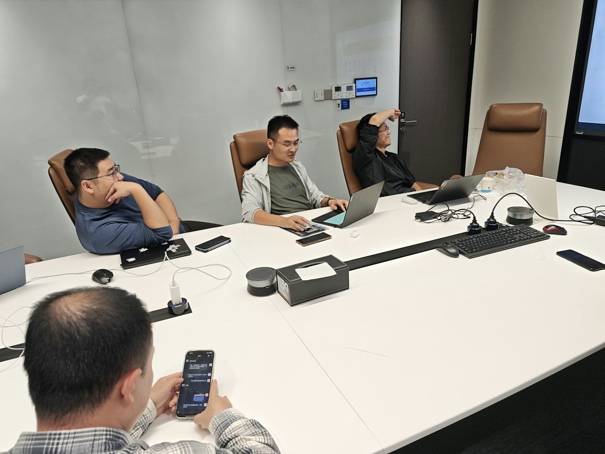 Bốn người đàn ông trong phòng họp với laptop